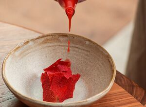 Détail d'un dressage Dialogues : sauce rouge versée sur une tuile